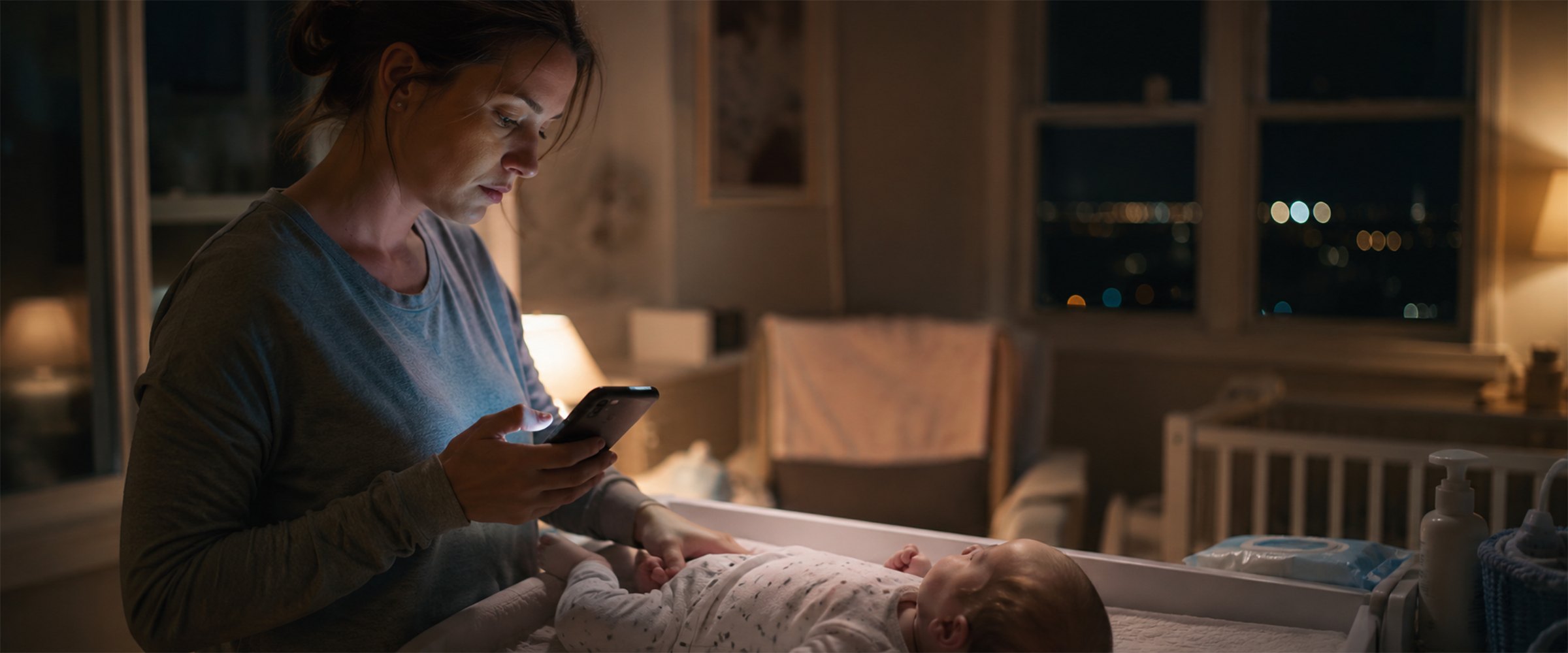 A parent checking Baby Playbook at night beside the changing table